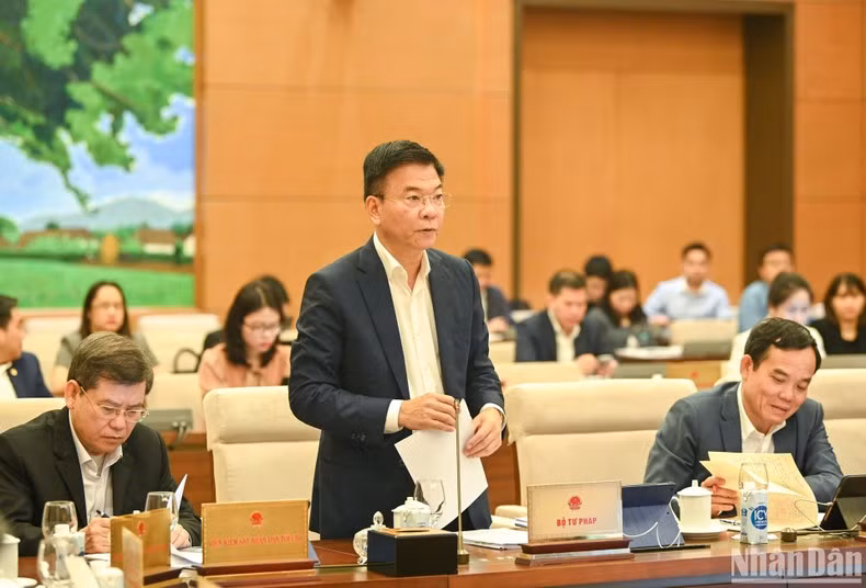 Minister of Justice Le Thanh Long presents a report at the session.