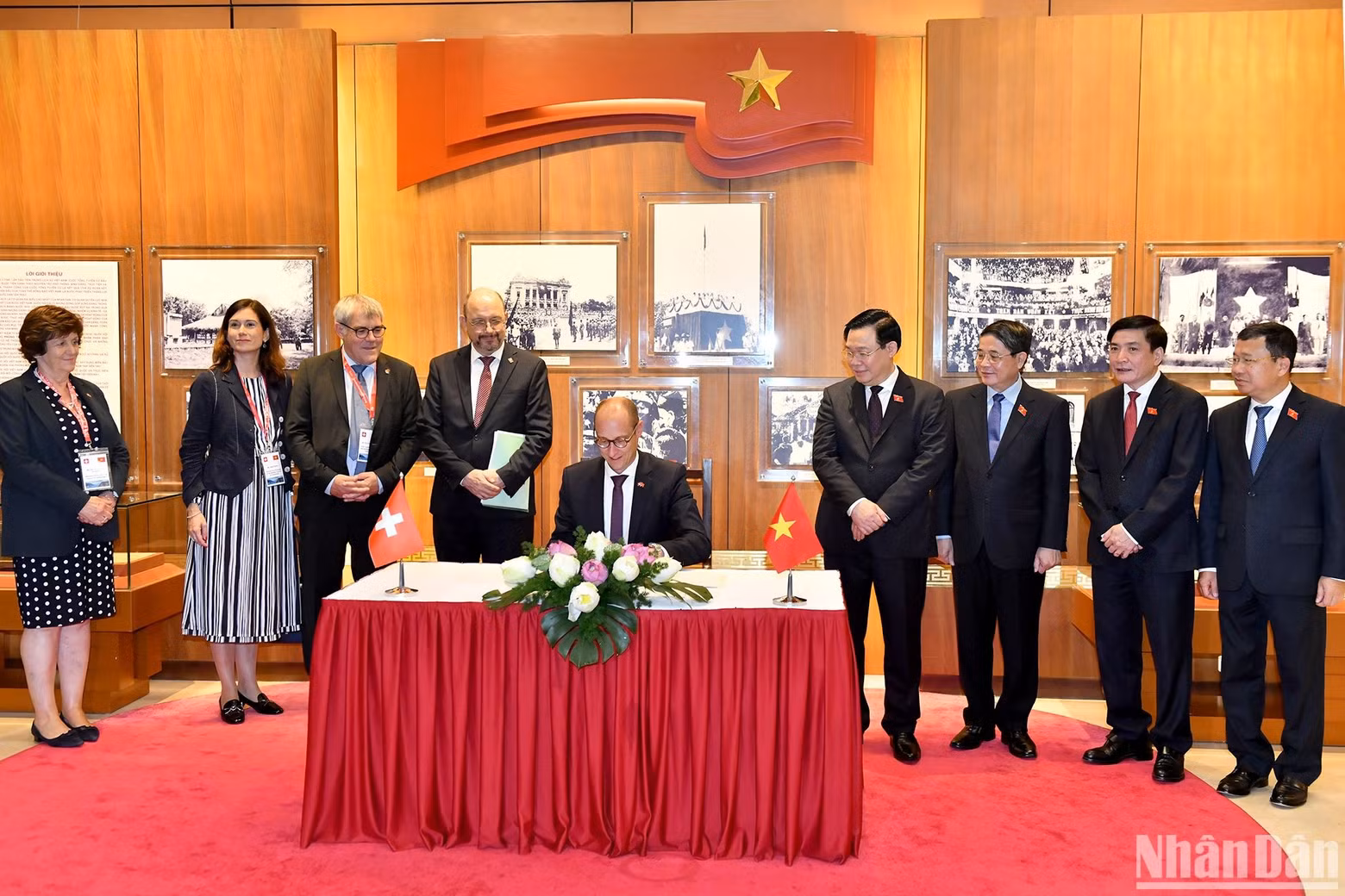 President of the National Council of Switzerland Martin Candinas writes on the golden guestbook at the Vietnam NA’s historical room, as a memento.