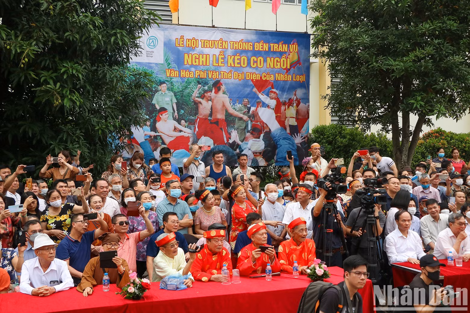 A large number of people participate and cheer, creating a lively atmosphere.
