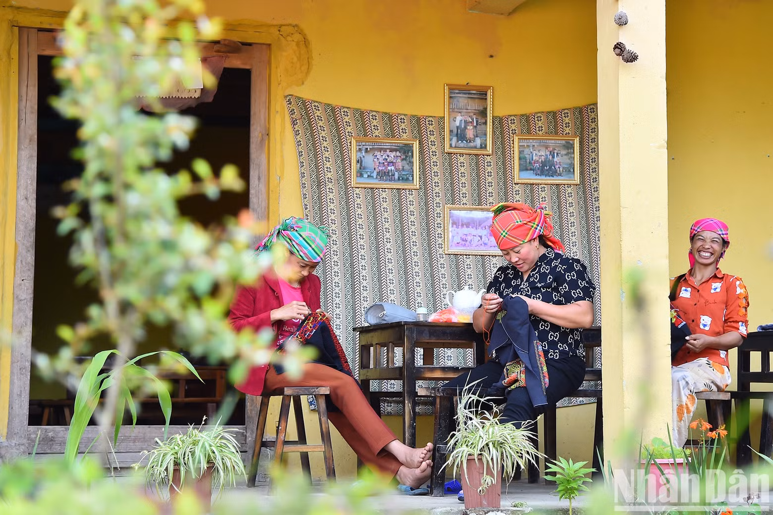 Peaceful moments of Lo Lo mothers and sisters sewing and embroidering on the front porch.