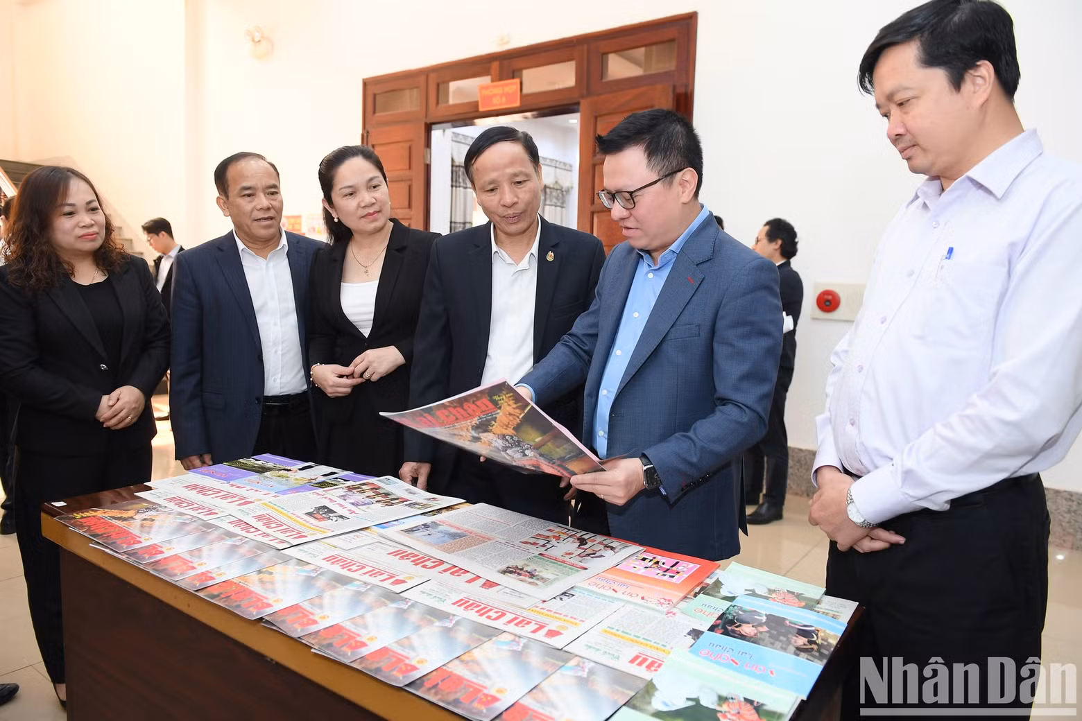 The Editor-in-chief of Nhan Dan Newspaper reads print publications of Lai Chau Newspaper and Lai Chau Arts Magazine.