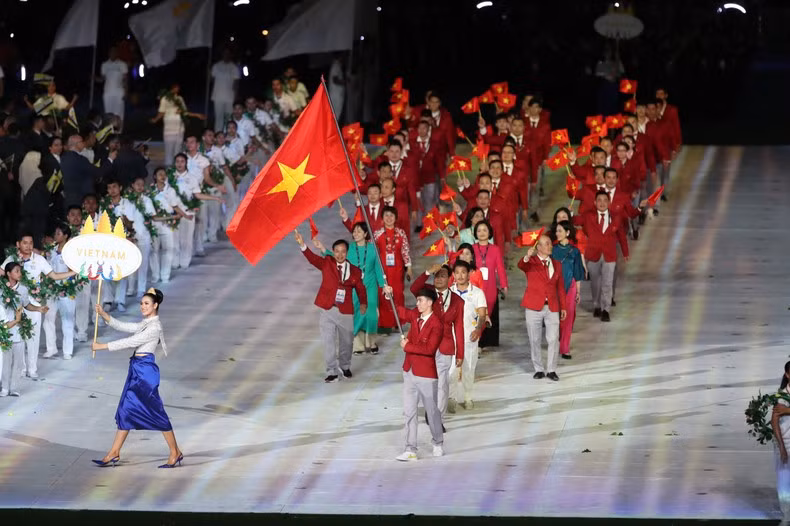 The Vietnamese sports delegation marches at the opening ceremony. Swimmer Nguyen Huy Hoang, who won eight SEA Games gold medals, holds the Vietnamese flag.