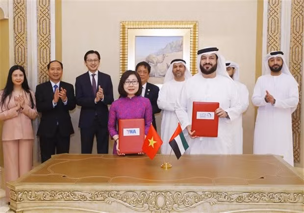 VNA Deputy Director General Doan Thi Tuyet Nhung and WAM Director-General Mohamed Jalal Al Rayssi sign a professional cooperation agreement between the two agencies. (Photo: VNA)