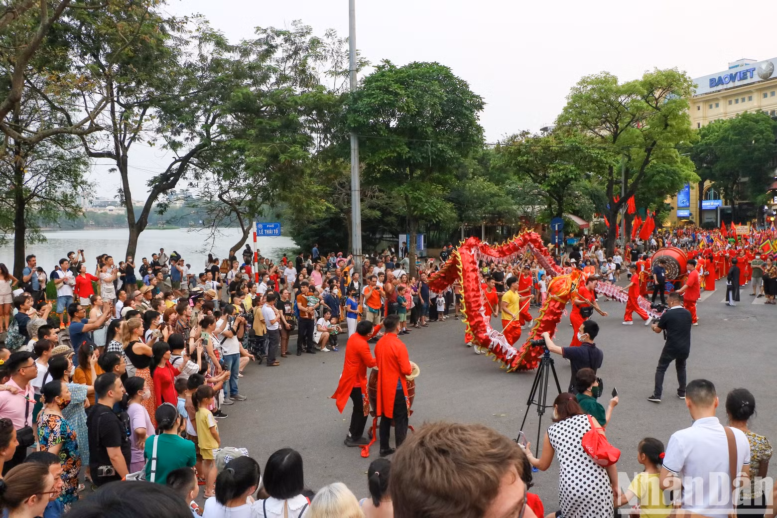 The procession attracts a large number of people who are interested and immersed in the festive atmosphere.