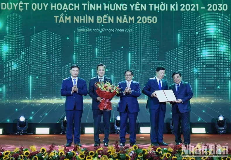 Prime Minister Pham Minh Chinh (C) and Minister of Planning and Investment Nguyen Chi Dung (first, R) present the decision approving Hung Yen's master plan to leaders of Hung Yen.
