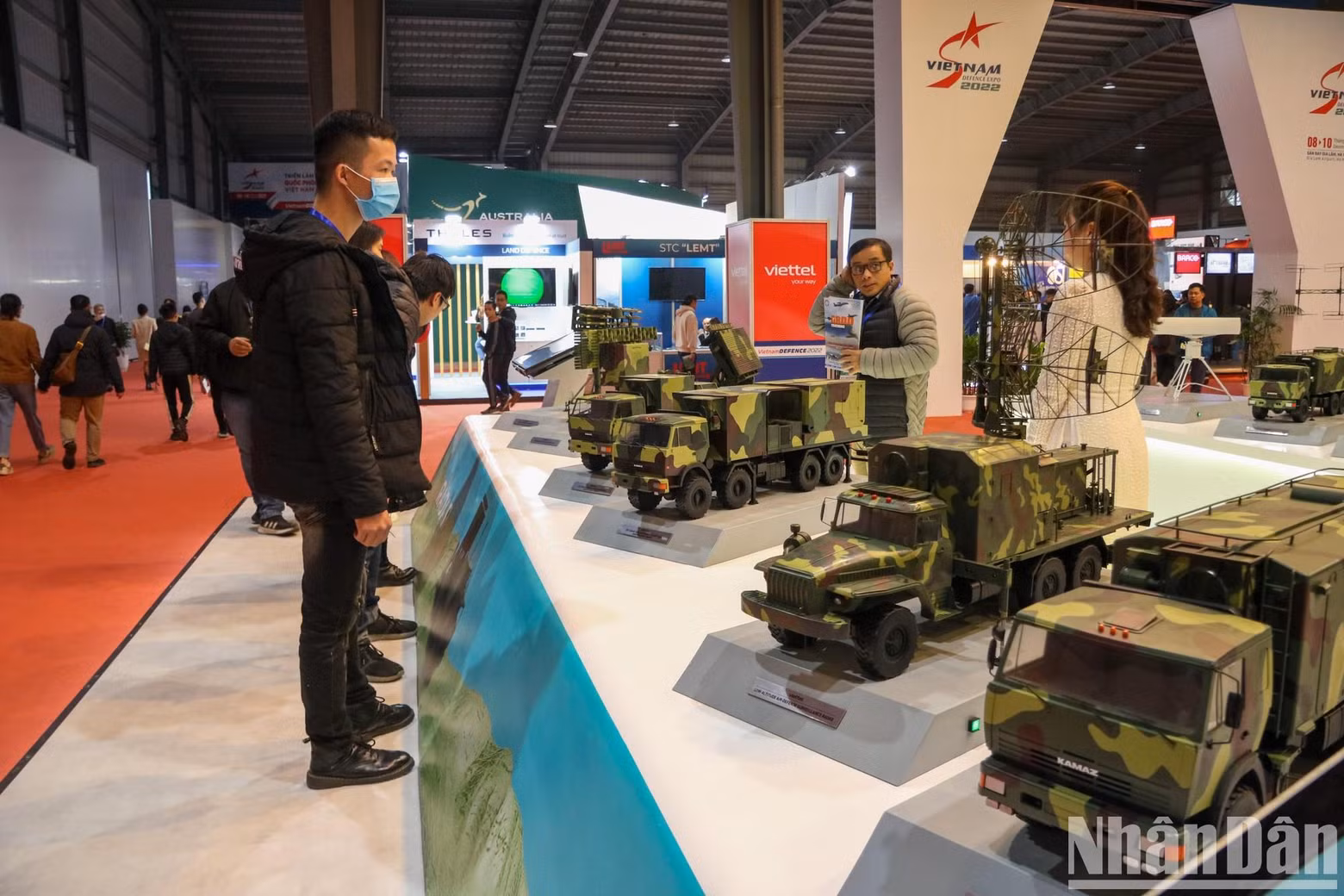 Visitors examine booths displaying military models at the expo. Visitors examine booths displaying military models at the expo.