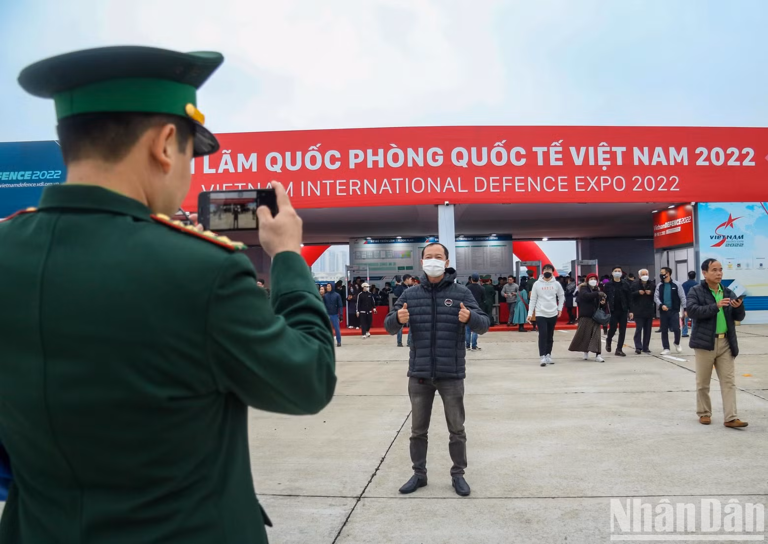 A soldier happily took a commemorative photo for a person at the entrance of the exhibition. A soldier happily took a commemorative photo for a person at the entrance of the exhibition.