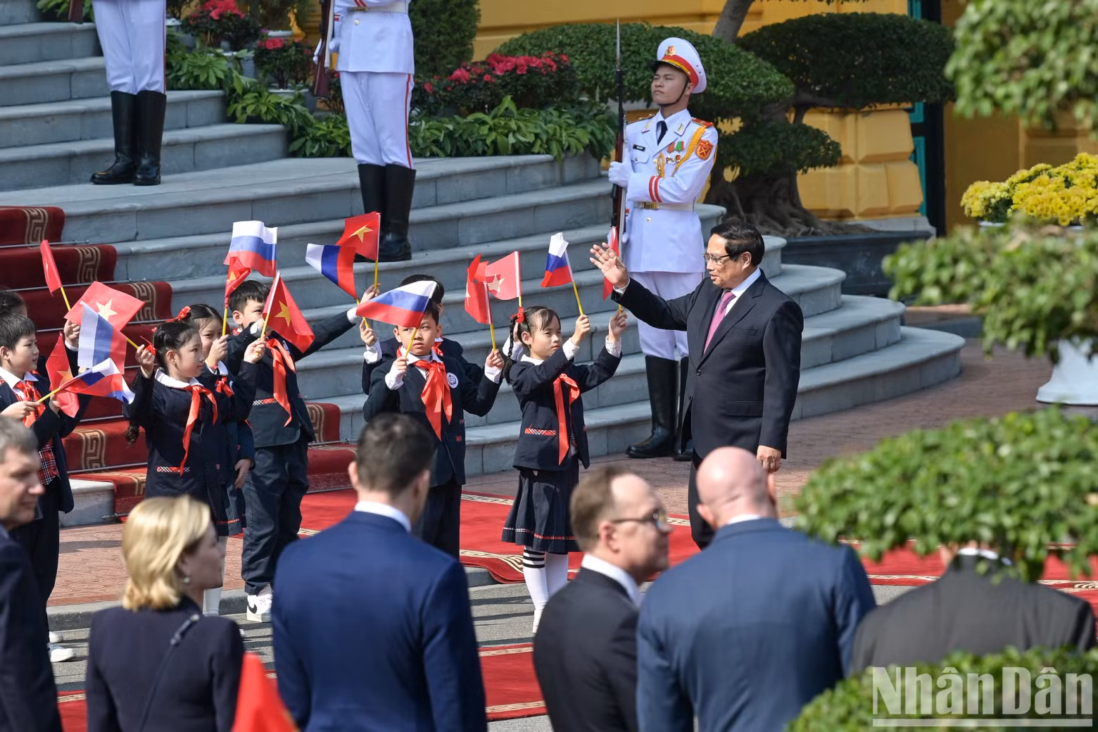 Prime Minister Pham Minh Chinh waves to children.
