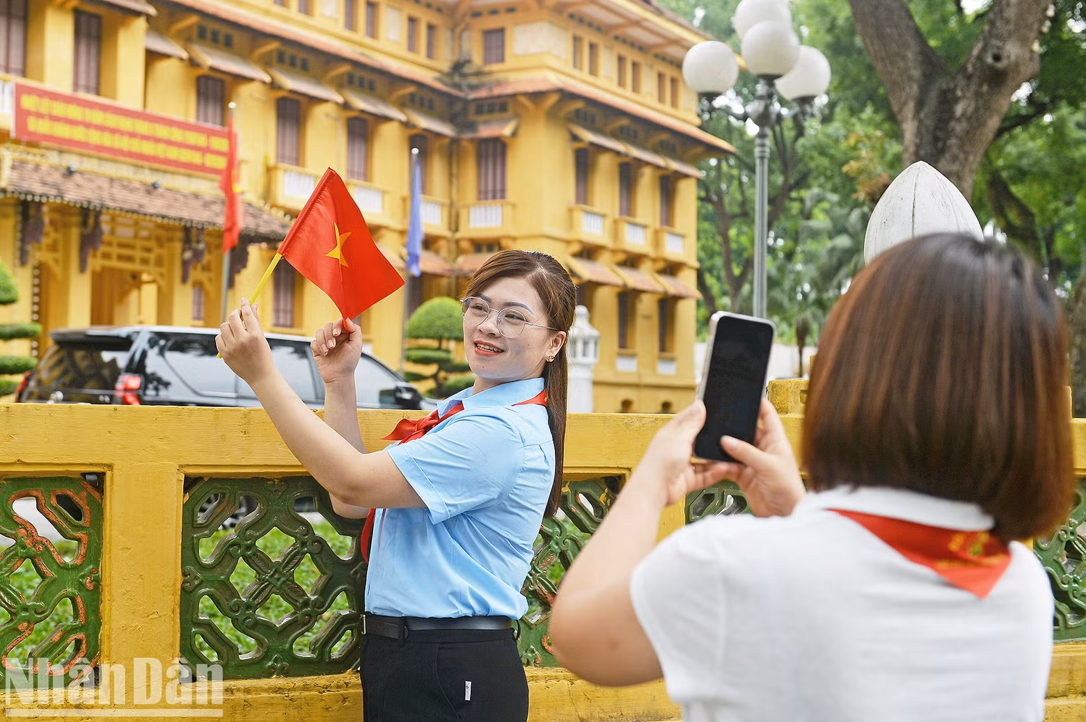 A Young Pioneers League official poses for a photo in front of the Ministry of Foreign Affairs headquarters.