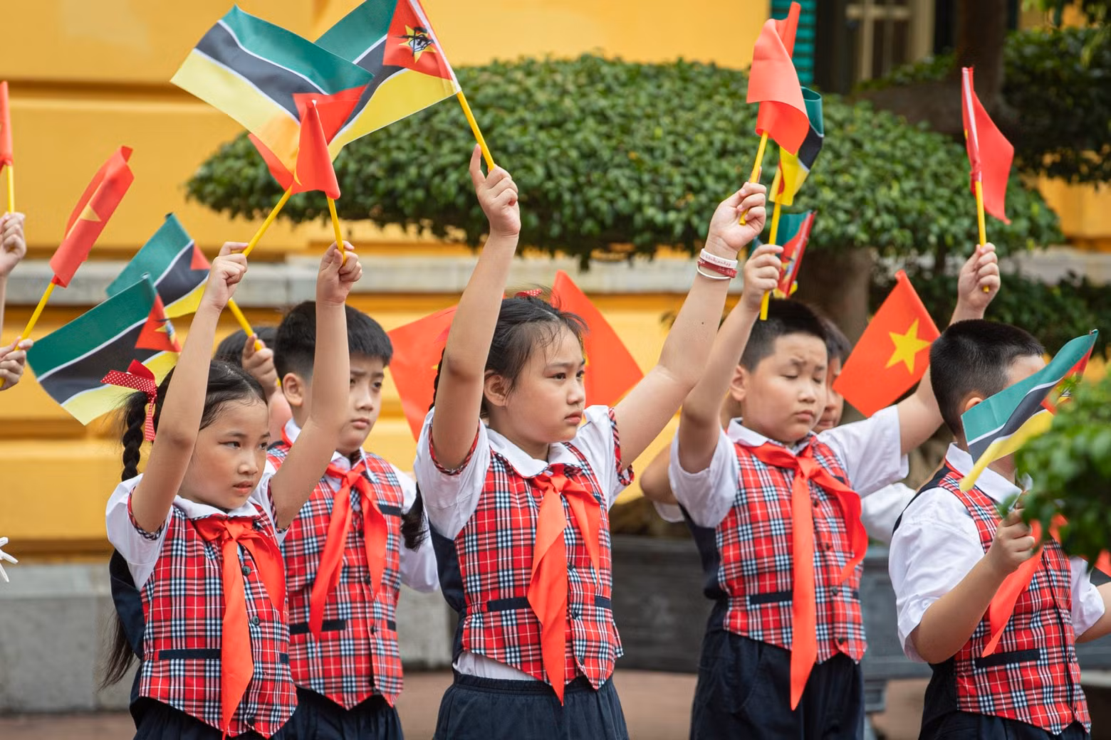 Vietnamese children wave flags to welcome Mozambican President Filipe Jacinto Nyusi.