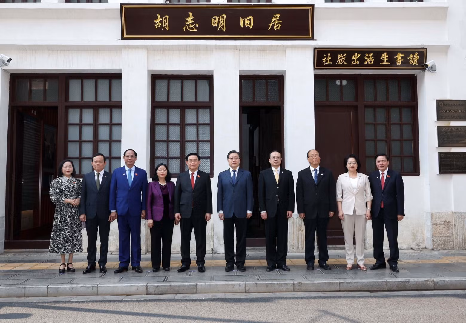 National Assembly Chairman Vuong Dinh Hue and Vice Chairperson of the Standing Committee of the National People's Congress (fifth from right) posing for a photo in front of the house (Photo: VNA)