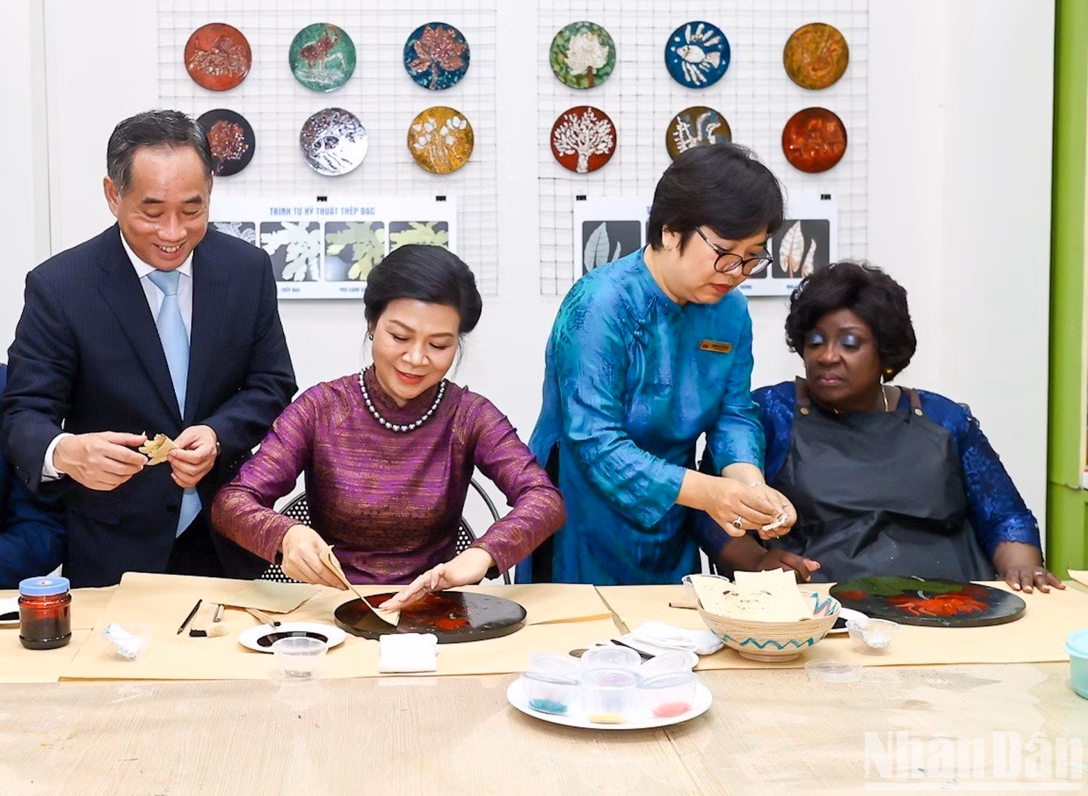 The two first ladies experience the process of making lacquer paintings.