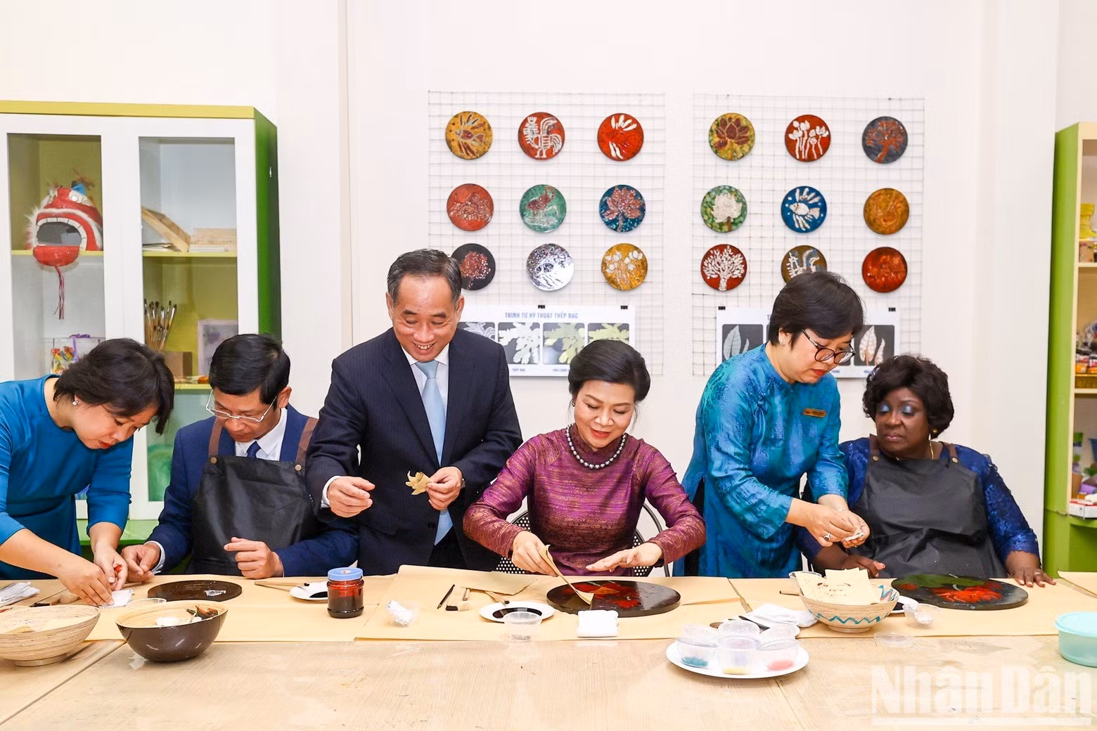 The two first ladies experience the process of making lacquer paintings.