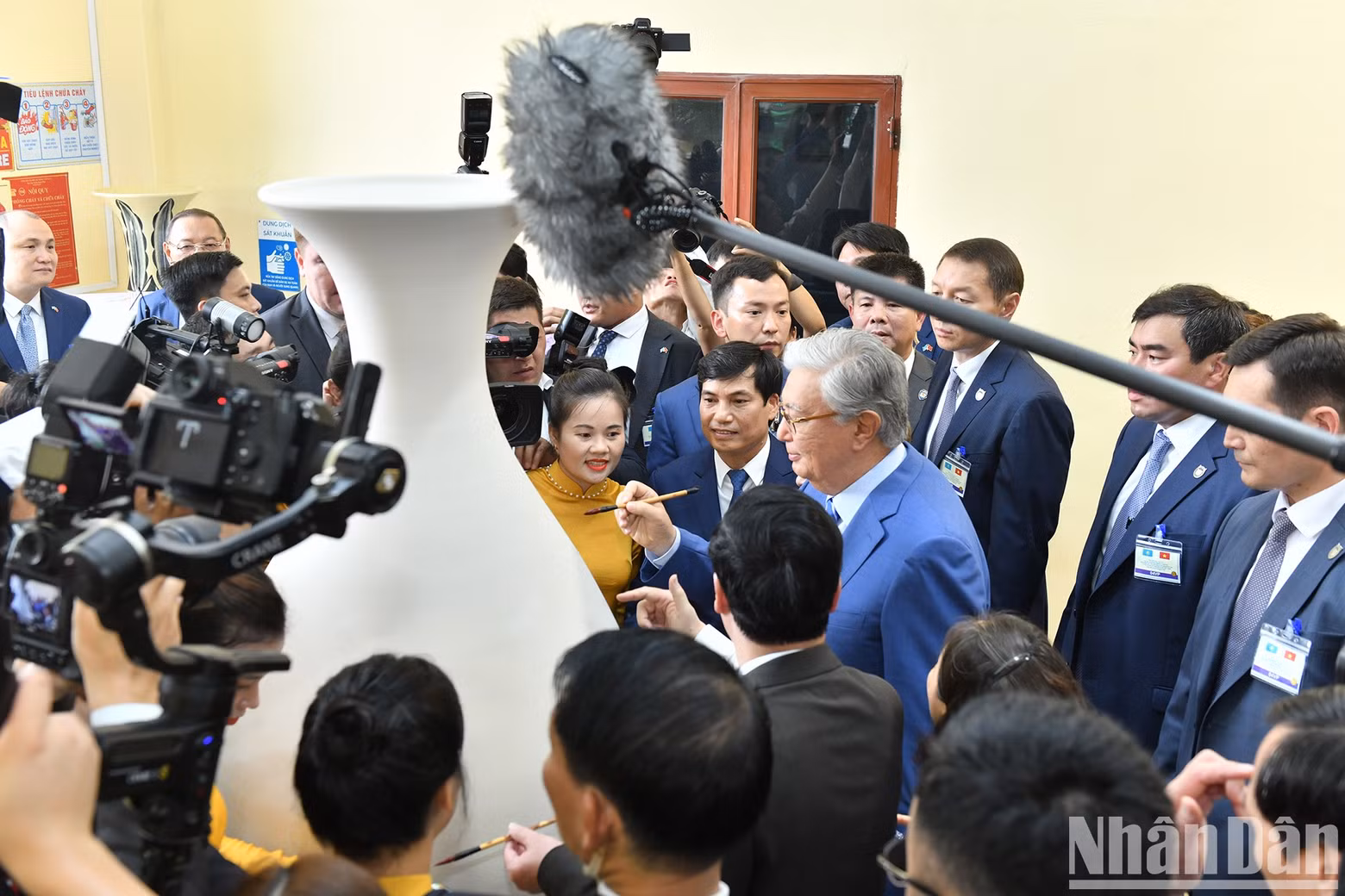 Kazakh President Kassym-Jomart Tokayev signs a pottery vase at the event.