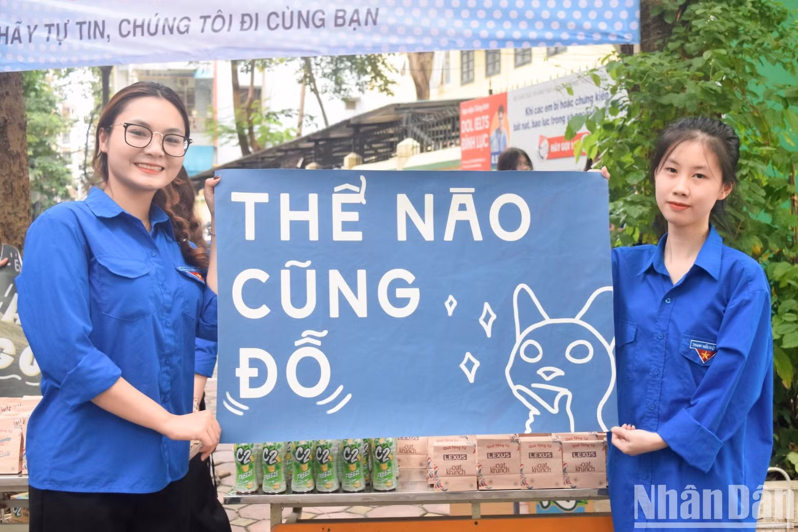 Two volunteers hold a slogan saying ‘You will surely pass the exam’ to encourage the candidates.