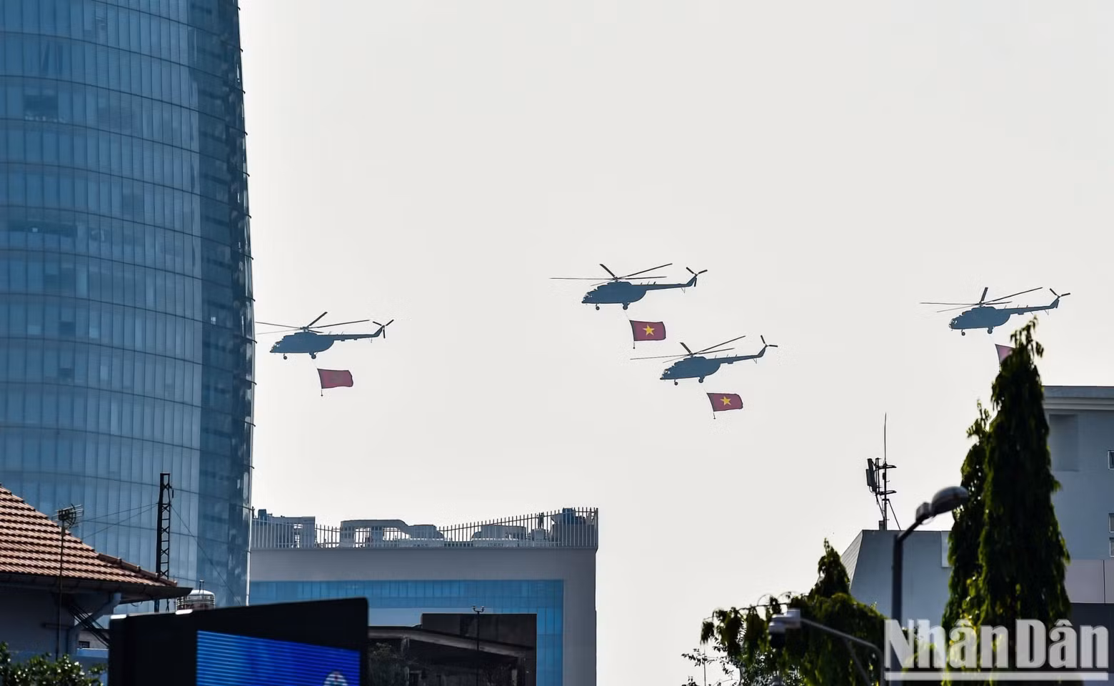 Helicopters carrying the Party and National flags over Ho Chi Minh City.