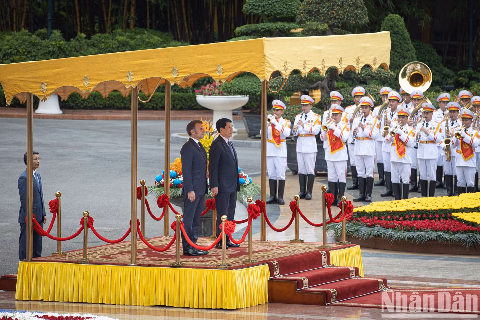 State President Luong Cuong and President Emmanuel Macron stand on the ceremonial platform as the military band plays the national anthems of both countries. State President Luong Cuong and President Emmanuel Macron stand on the ceremonial platform as the military band plays the national anthems of both countries.