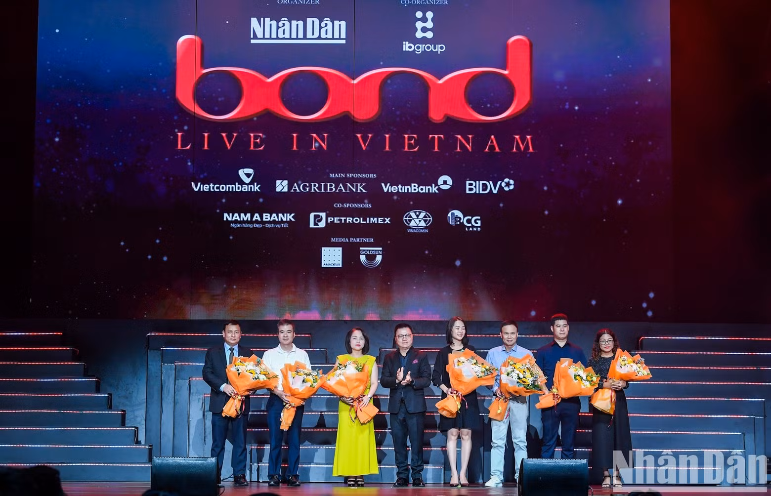Nhan Dan’s Editor-in-chief Le Quoc Minh presents flowers the concert’s sponsors ahead of the Bond performance.