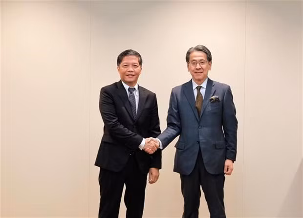 Head of the Party Central Committee's Economic Commission Tran Tuan Anh (L) and a representative of the Japan Bank for International Cooperation (JBIC). (Photo: VNA)