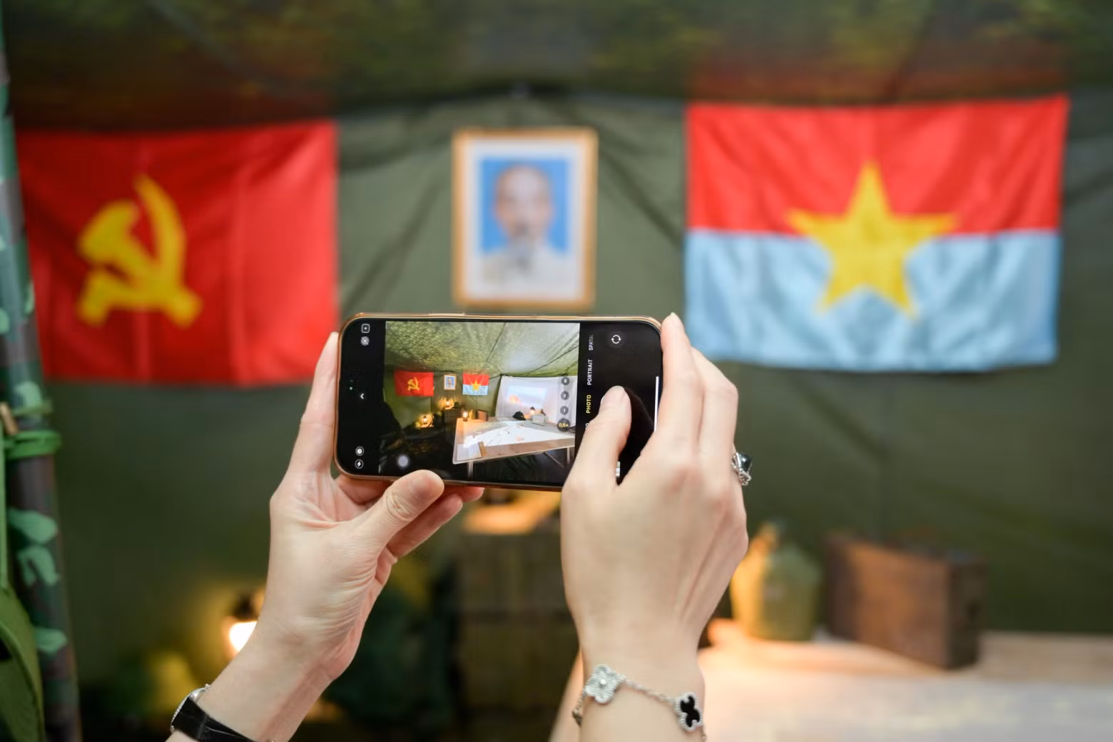 Visitors capture the recreated space of a field tent at the exhibition.