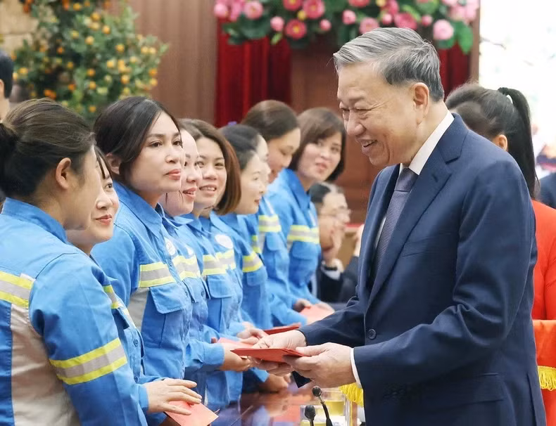 Party General Secretary To Lam gives li xi (lucky money) to workers. (Photo: Thong Nhat/VNA)