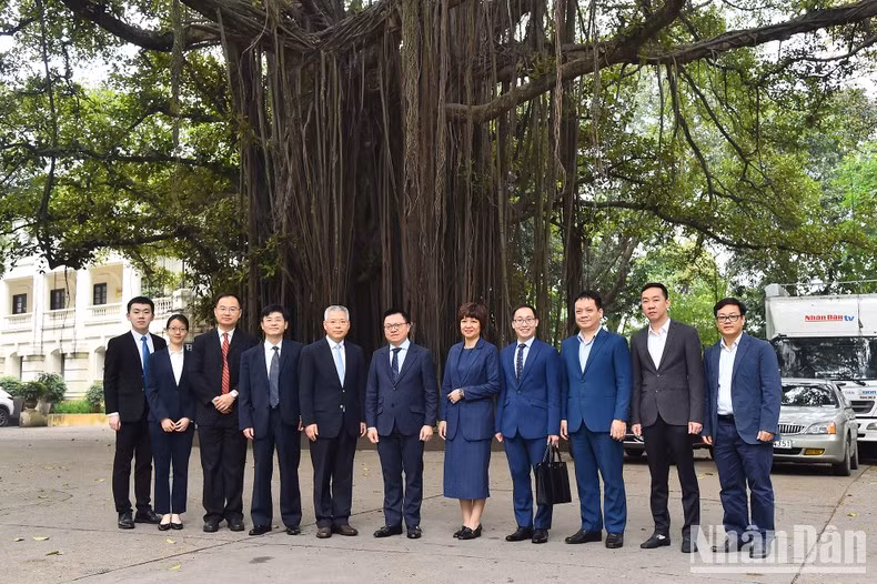 Le Quoc Minh, Hu Zhaoming and other delegates take photos beside the banyan tree at Nhan Dan Headsquarters. Le Quoc Minh, Hu Zhaoming and other delegates take photos beside the banyan tree at Nhan Dan Headsquarters.