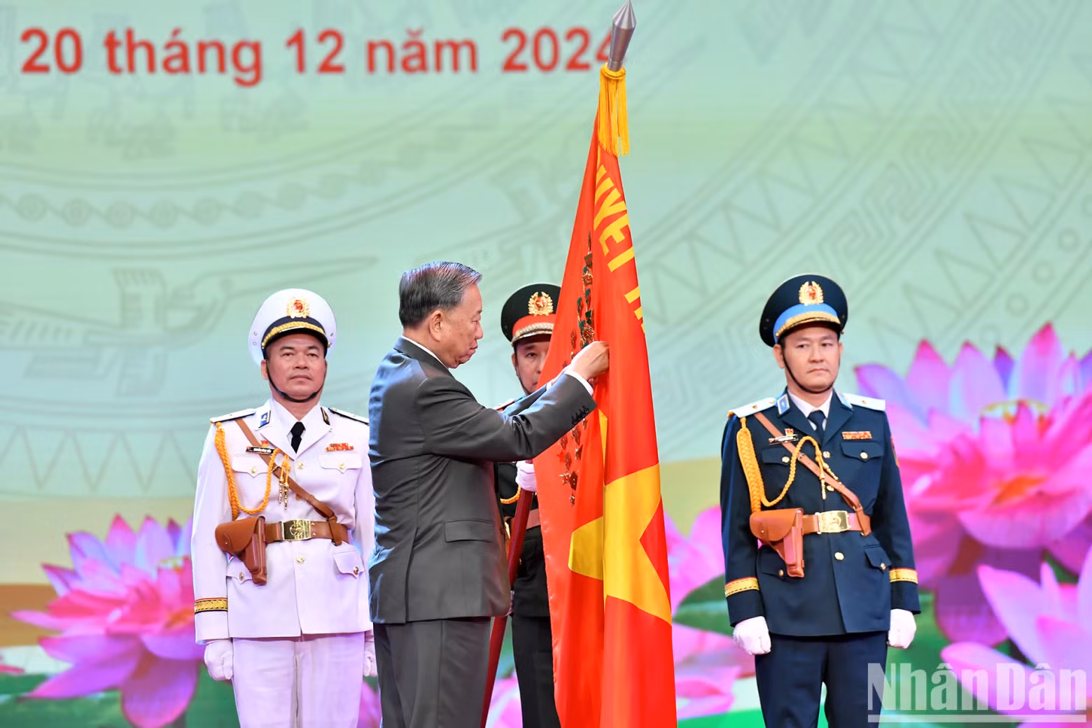 General Secretary To Lam pinning the Ho Chi Minh Medal on the Military Flag.