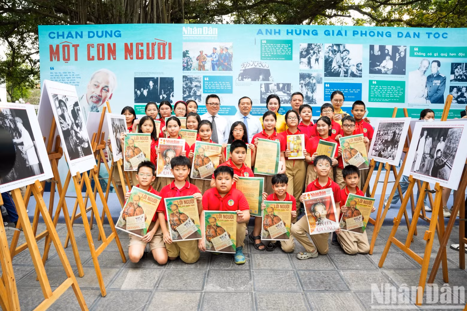 Delegates take photos with students at the exhibition.