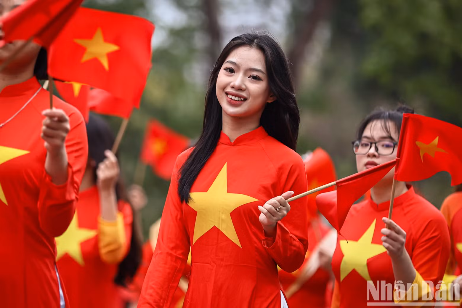Young women in Ao Dai with the national flag.