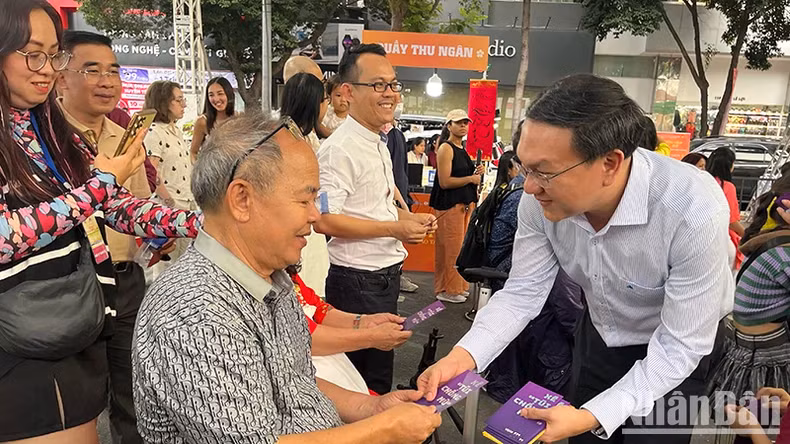 Lam Dinh Thang, Director of the Department of Information and Communications of Ho Chi Minh City, gives lucky books to guests attending the programme.
