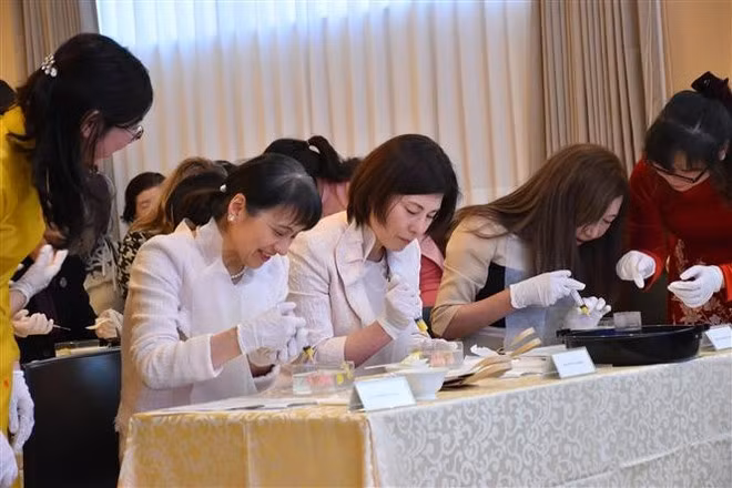 Guests, including Princess Takamado and the wife of the Japanese Prime Minister, have the opportunity to create 3D jelly flowers under the guidance of Vietnamese artisan Tran Phuong Nga. (Photo: VNA) Guests, including Princess Takamado and the wife of the Japanese Prime Minister, have the opportunity to create 3D jelly flowers under the guidance of Vietnamese artisan Tran Phuong Nga. (Photo: VNA)
