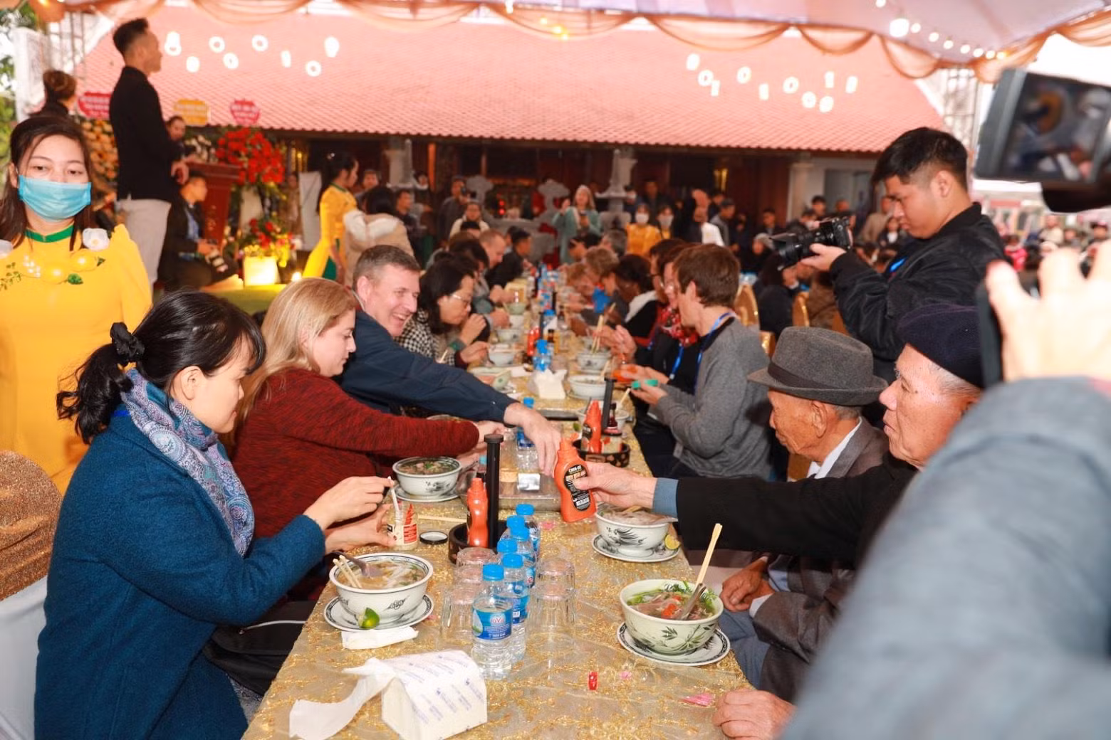 Vietnamese and foreigners enjoy bowls of pho.