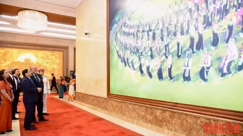 Prime Minister Pham Minh Chinh introduces pictures of the Vietnamese country and people to Cuban Prime Minister Manuel Marrero Cruz. (Photo: Tran Hai)