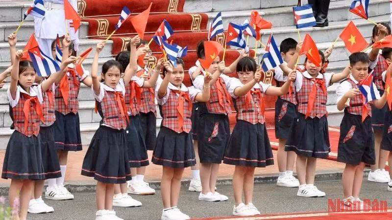 Hanoi children wave flags to welcome Prime Minister Pham Minh Chinh and his Cuban counterpart Manuel Marrero Cruz. (Photo: Tran Hai)