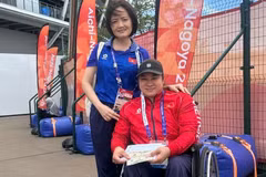 A representative of the Vietnamese para sports delegation presents a bonus to Nguyen Thi Ngoc Thuy after winning bronze in the women’s discus throw F54 at the 5th Asian Para Games in Nagoya, Japan. (Photo: THU HOAI)