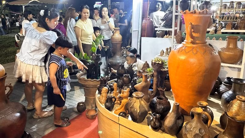 Local residents and visitors admire Bau Truc pottery on display at the festival grounds.