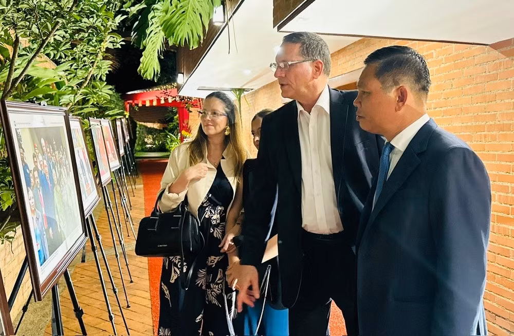 Ambassador Vu Trung My acquaints delegates with images highlighting Viet Nam–Venezuela relations on display at Viet Nam House in Caracas. (Photo courtesy of the Vietnamese Embassy in Venezuela)