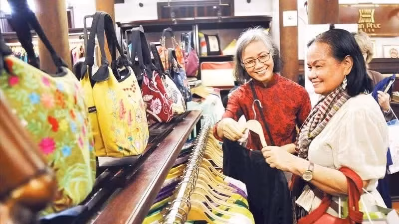 Tourists shop at a showroom selling products from Van Phuc silk weaving village. (Photo: NDO)