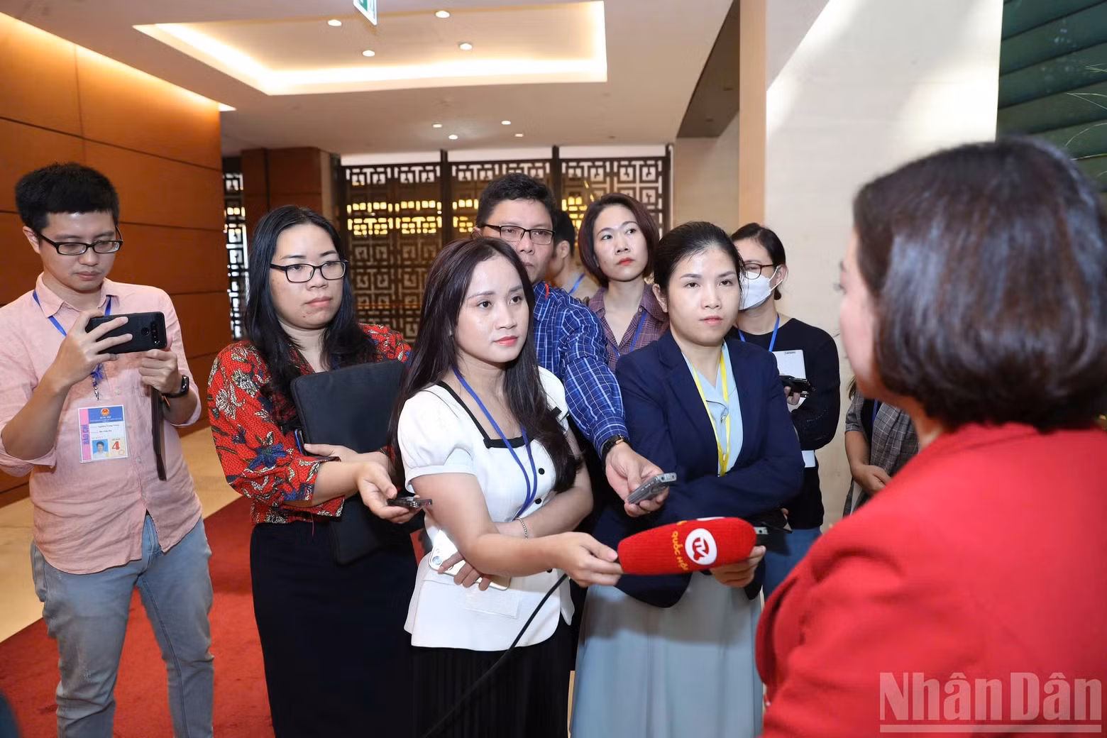 Journalists report in the corridors of the National Assembly.