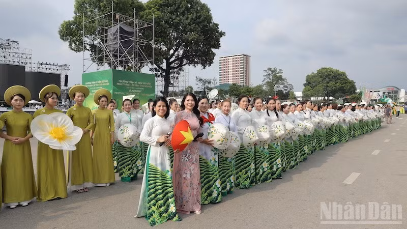 Women from Thai Nguyen stand out in “Ao dai” adorned with tea flower motifs during a mass performance.