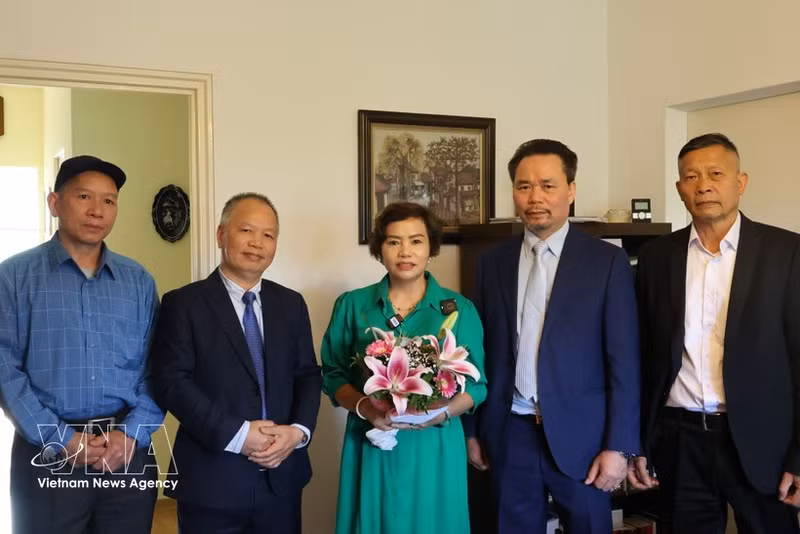 Delegation members visit the family of Tran Thi Yen (centre), daughter of martyr Tran Quang Tien. (Photo: VNA)