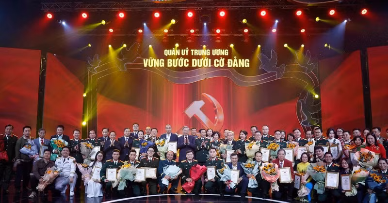 Party General Secretary To Lam and Minister of National Defence General Phan Van Giang pose for a photo with the award-winning authors and author groups. (Photo: VNA)