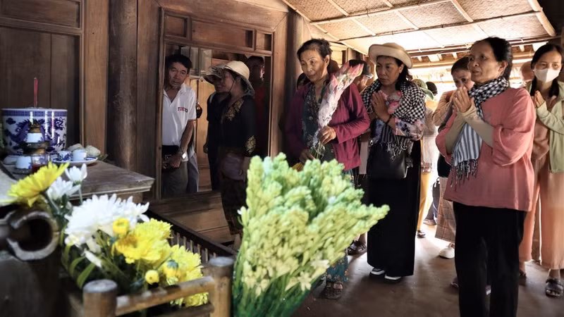 Offering bouquets of lotus flowers and lilies are respectfully offered.