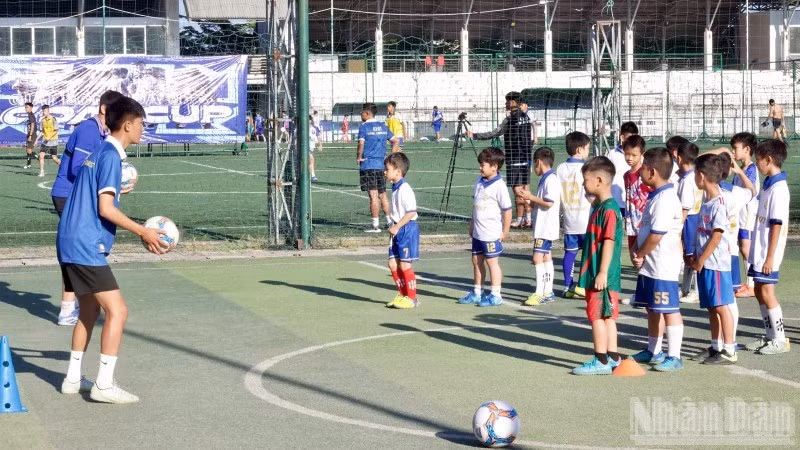 Young football players learn football skills under the guidance of their coach.