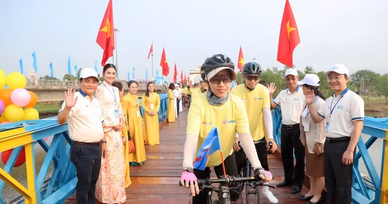 Cyclists parade across Hien Luong Bridge.