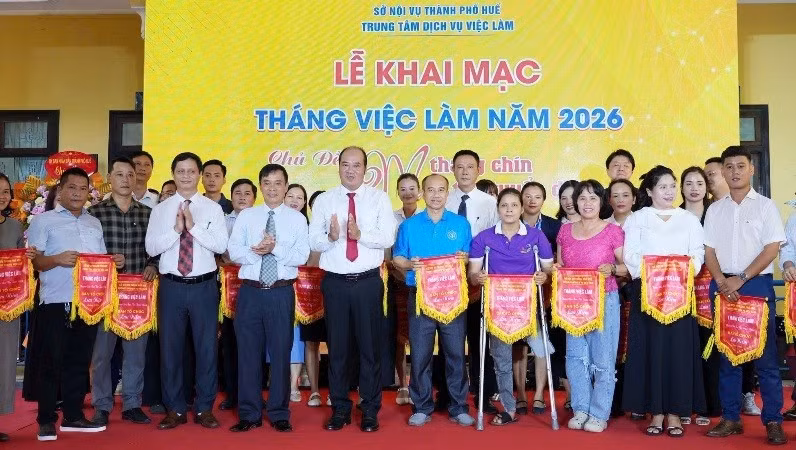 Nguyen Van Manh, Vice Chairman of the Hue City People’s Committee, presents commemorative flags to organisations participating in the programme.