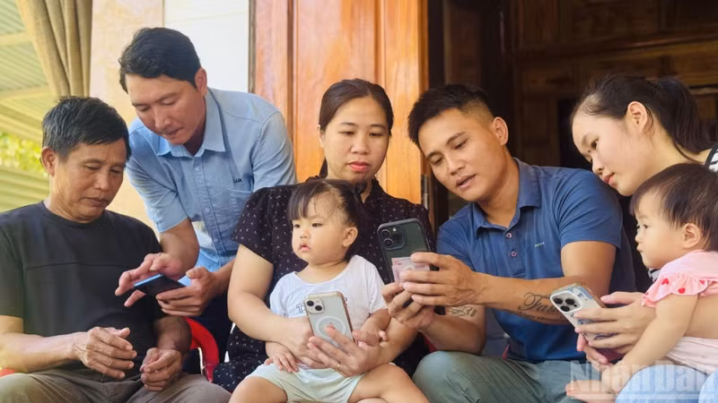 Members of a Community Digital Technology Team visit households in Phong Nha Commune to provide hands-on guidance, helping residents install and use digital citizen applications on their smartphones. (Photo: HNV)