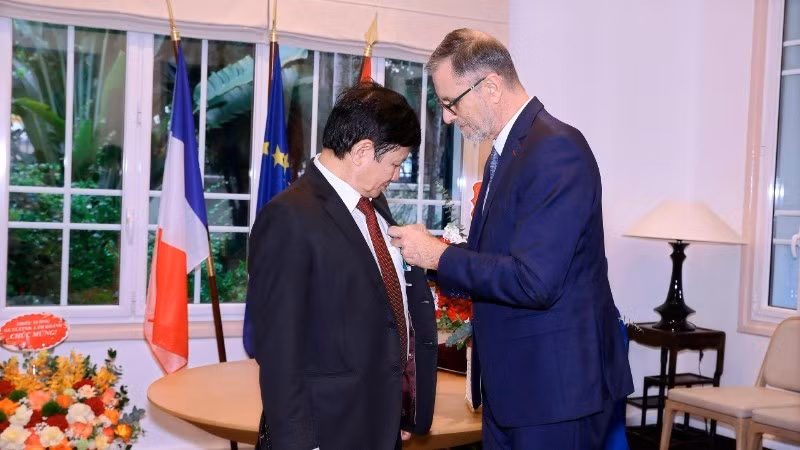 French Ambassador to Viet Nam Olivier Brochet presents the French National Order of Merit to Prof, Dr Le Danh Tuyen.