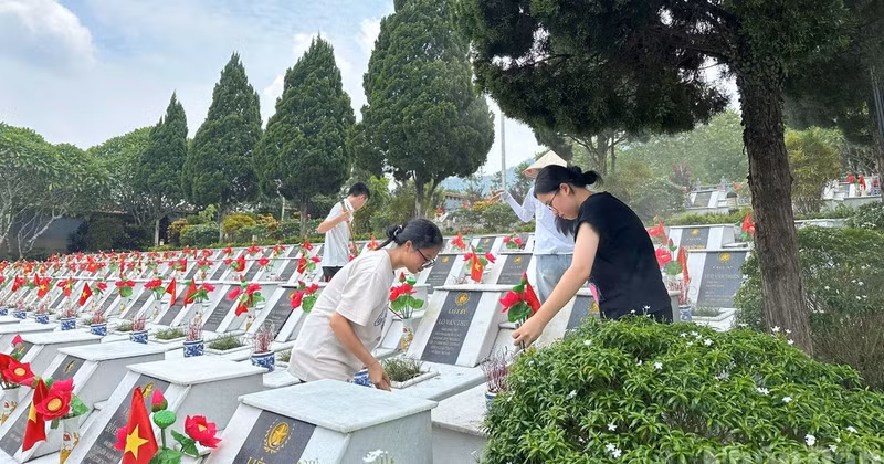 Students clean the grounds of the Vi Xuyen Martyrs’ Cemetery.
