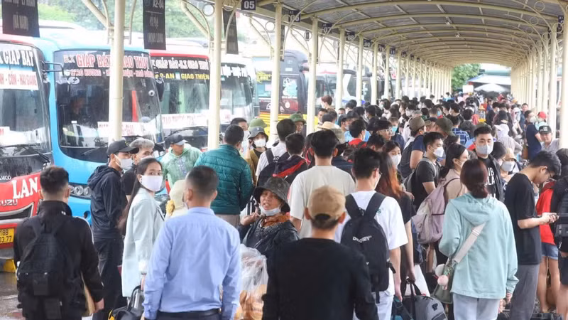 Passengers board buses at Giap Bat bus station (Ha Noi).